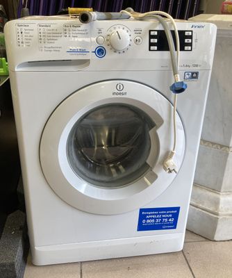 une machine à laver posée sur le sol