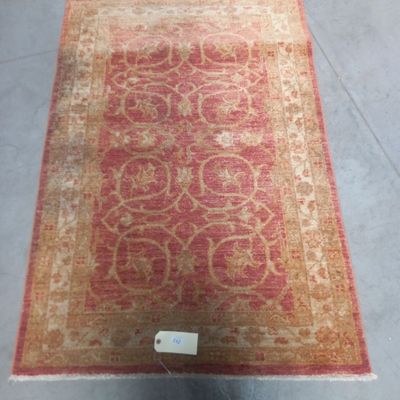un gros plan d'un tapis rouge et beige posé sur le sol