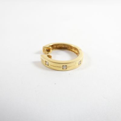gros plan d'une bague en or sur une surface blanche