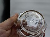 a person holding a glass jar with a sticker on it