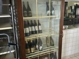 des bouteilles de vin se trouvent dans une vitrine en verre dans une cuisine