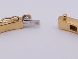 a close up of two gold bracelets on a white surface
