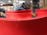 une chaise rouge dans une pièce où se trouvent de nombreuses chaises rouges