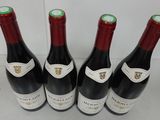 four bottles of wine are lined up on a table