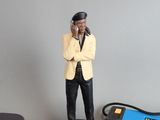 a figurine of a man in a yellow jacket and black pants