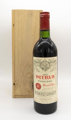 une bouteille de vin rouge devant une caisse en bois
