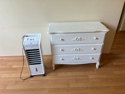 une commode blanche et un climatiseur blanc dans une pièce