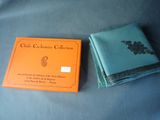 an orange and blue book sitting on top of a table next to a blue cloth