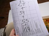a person holding a piece of paper with numbers on it