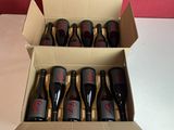 six bouteilles de vin sont posées sur une table dans un carton