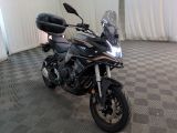 a black motorcycle parked in a room with a checkered floor