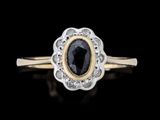 un gros plan d'une bague sertie d'un diamant noir posée sur une surface noire