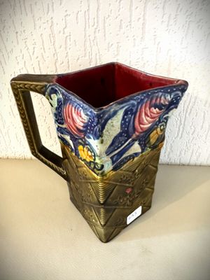un pichet bleu et rouge posé sur une table