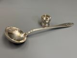une cuillère en argent et une salière posées l'une à côté de l'autre sur une table