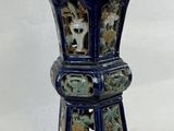 a blue vase with a design on it on a white background