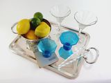 a tray that has a bowl of lemons and two glasses on it