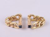a pair of gold tone cuff earrings with black stones