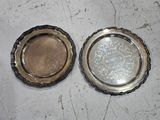deux assiettes en argent posées l'une à côté de l'autre sur une table
