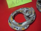 deux serpents posés sur une surface rouge, avec une étiquette jaune