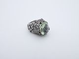 a close up of a ring with a green stone in it