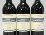trois bouteilles de vin du Château Monergase posées les unes à côté des autres