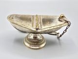 a silver plate with a chain around it on a table