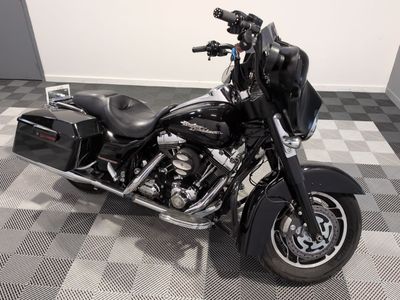 une moto noire garée sur un sol à damier