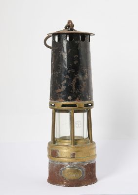 an old fashioned brass and glass lantern on a white surface