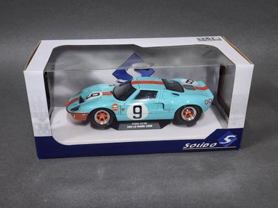 la boîte est ouverte pour montrer la maquette d'une voiture de course bleue