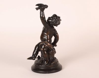 statue en bronze représentant un garçon avec un oiseau sur la main