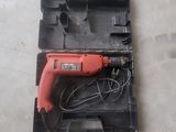 a corded drill in a plastic case on the floor