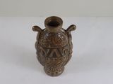 a brown vase with a design on it on a white surface