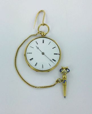 a small gold pocket watch with a chain around it