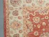an orange and beige rug with a floral design on a gray floor