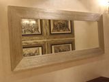 un miroir sur le mur au-dessus d'un lavabo dans une salle de bains