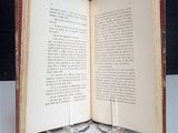 an open book on a table with a candle on it