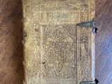 an old book sitting on top of a wooden table on a table
