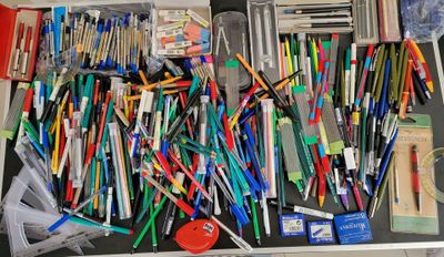 a lot of pens and pencils that are in a suitcase