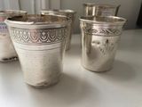 three silver cups sitting on a table next to each other