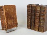 paire de livres anciens reliés en cuir, posés sur un support métallique