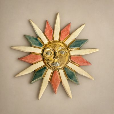 un soleil avec un visage dessus, accroché au mur