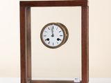 a small wooden clock sitting on a white table