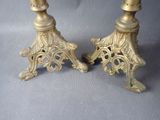 pair of antique brass candlesticks on a gray background