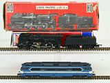 two model trains sitting on the tracks next to each other