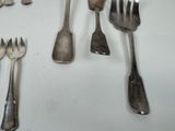 a lot of forks and spoons that are on the table