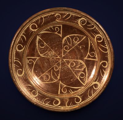 une image représentant une assiette en or ornée de motifs