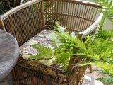 une chaise en osier et une table sur une terrasse en briques