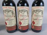 three bottles of red wine sitting next to each other on a table