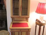 a wooden cabinet with a red cushion on top of it