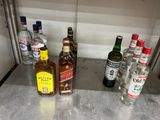 bottles of alcohol are lined up on a counter in a kitchen